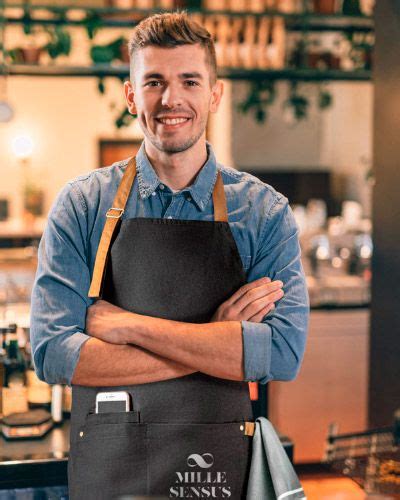 A Man Standing With His Arms Crossed Wearing An Apron