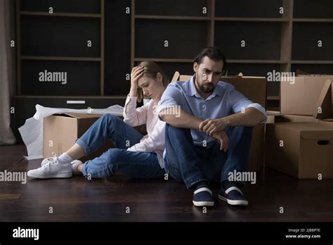 Tired Married Couple Sit On Floor Near Cardboard Boxes Stock Photo Alamy