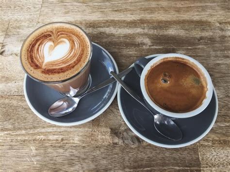 Premium Photo Two Coffees On Wooden Table