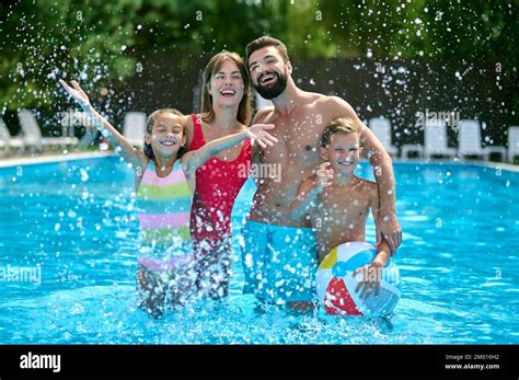 Padres J Venes Y Modernos Felices Y Sus Hijos Agradables De Pie En La