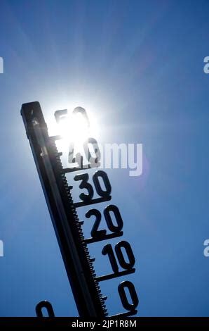 Image symbolique réchauffement climatique thermomètre devant le