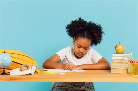 Colegiala Afroamericana Feliz Haciendo La Tarea En El Escritorio En