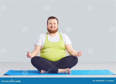 Positive Fat Man Yogi Does Yoga Exercises A Gray Background. Stock ...