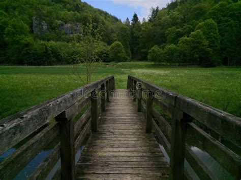 Beautiful Rustic Bridge Spanning A Tranquil Lake And Leading To A Lush