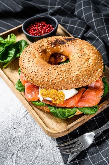 Sándwich de bagel con salmón queso crema espinacas y huevo en un