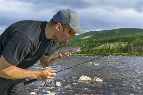 Fisherman Lick Fresh Fish His Tongue Trout Fishing On Wild River Stock