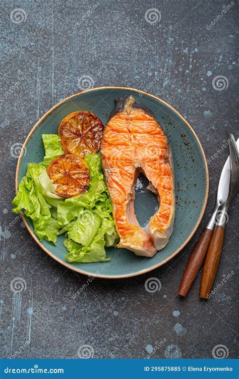 Grilled Fish Salmon Steak And Green Salad With Lemon On Ceramic Plate