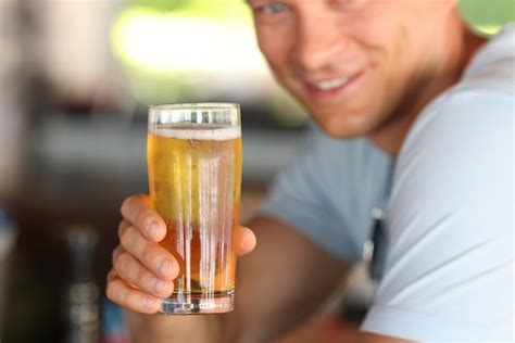 Premium Photo Smiling Young Man Holding Glass Of Beer