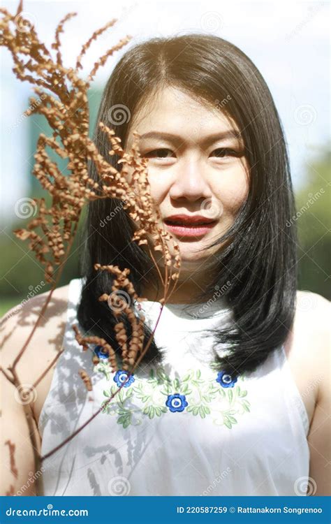 Beautiful Asian Woman In White Dress Smiling And Hand Holding Dry Twigs