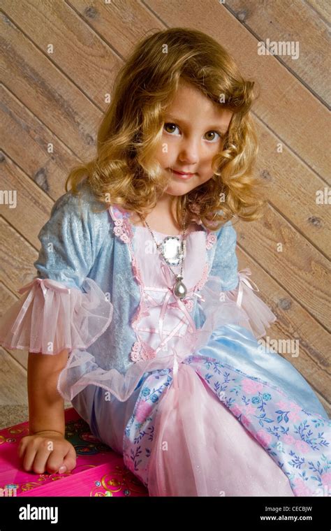 Proud But Serious A Three Year Old Blonde Girl Shows Off Fancy Clothes From Her Treasure Chest