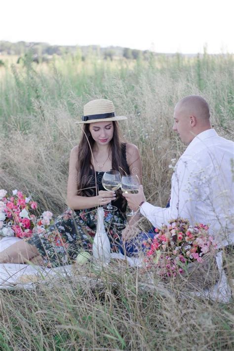 Husband And Wife On A Romantic Date On A Picnic Drinking Wine Happy Couple Brunette And Bald