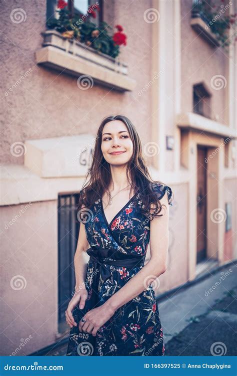 Cheerful Optimistic Brunette In A Flower Dress On The Street Stock