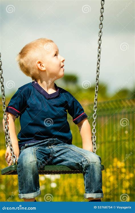 Little Blonde Boy Child Having Fun On A Swing Outdoor Stock Photo