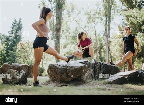 Fit Girls Stretching And Warming Up Outdoors In A City Park Enjoying