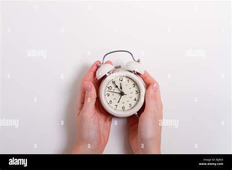 Woman S Hand Holding An Alarm Clock Stock Photo Alamy