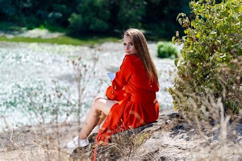 Femme En Robe Rouge Assise Sur Un Rocher Dans Un Cadre Serein Une Femme