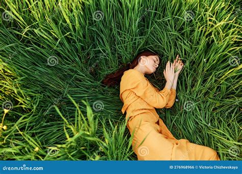 A Relaxed Woman Enjoys Summer Lying In The Tall Green Grass With Her Eyes Closed Photo Taken