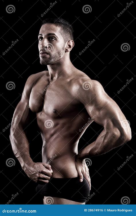 Homem Muscled Em Um Fundo Preto Foto De Stock Imagem De Poderoso