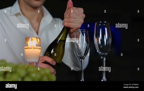 Nahaufnahme eines jungen Mannes der eine Flasche Champagner öffnete