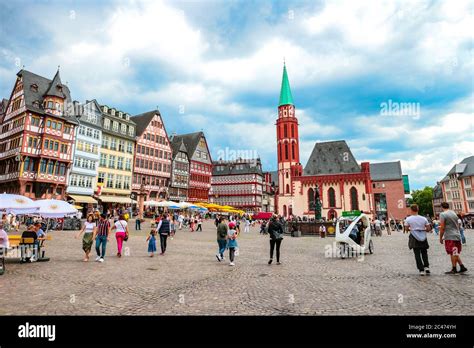 Los turistas en la histórica plaza Römerberg con la antigua iglesia de