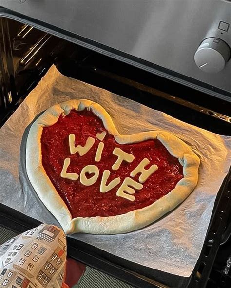 A Heart Shaped Pizza Sitting On Top Of A Pan In An Oven With The Word