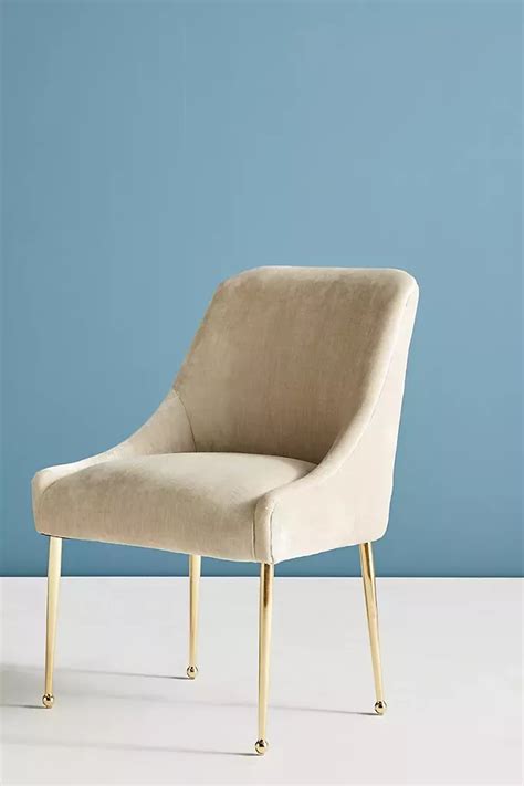 A Beige Chair Sitting On Top Of A White Floor Next To A Blue Wall And