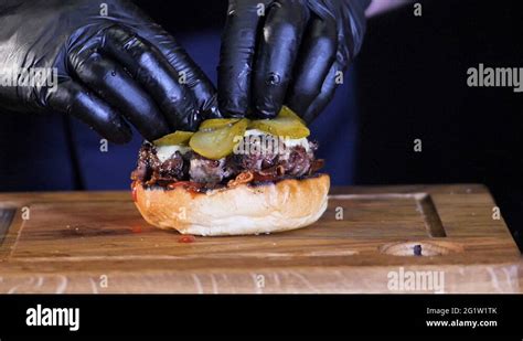 Concept of adding the ingredients to black Cheese Burger, grilled meat, cheese Stock Video ...