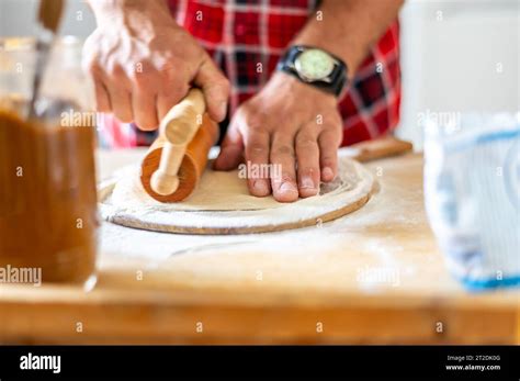 Detail Of Hands Of Men Rolling The Dough Preparation For Baking Of