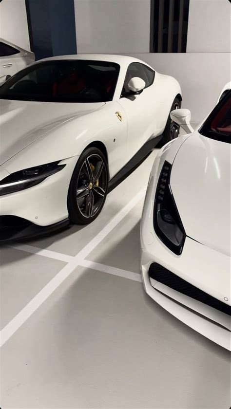 Two White Sports Cars Parked Next To Each Other In A Room With No One