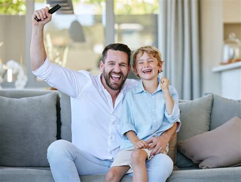 His Favourite Team Just Scored A Handsome Mature Man Relaxing On The Sofa At Home Stock Photo