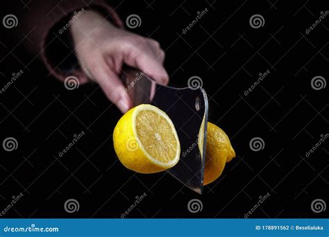 Hand With Knife Slicing A Lemon In Half In The Air Stock Photo Image