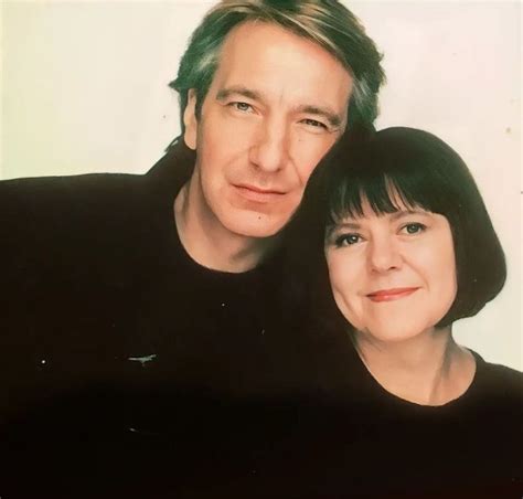 A Man And Woman Are Posing For A Photo In Front Of A White Background