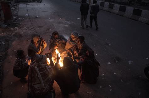 New Delhi People Sit Around A Fire To Warm Themselves During Cold