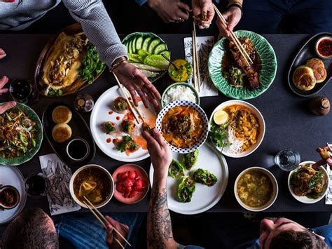 A Wooden Table Topped With Lots Of Plates And Bowls Filled With