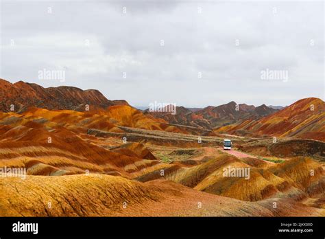 A View Of A Bus On A Road In Danxia Landform Cheltenham Badland In