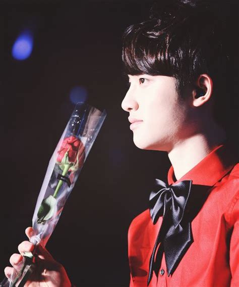 A Boy In A Red Shirt And Bow Tie Holding A Glass With Flowers On It