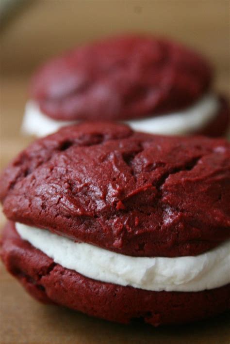 Red Velvet Whoopie Pies Sitting On A Butcher Block Filled With Cream