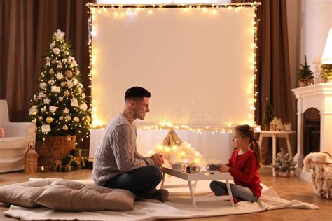 Father And Daughter Near Video Projector Screen At Home Cozy Christmas