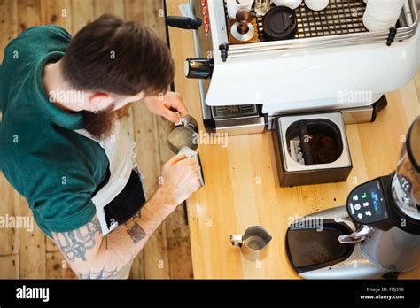 Top View Portrait Of Barista Pouring Milk Into Cup Of Coffee At The