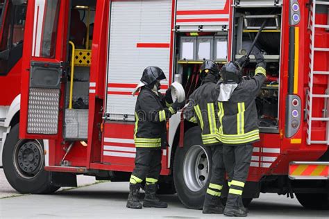 Firefighters In Action With The Fire Truck During The Emergency With