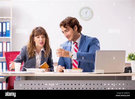 Two Colleagues Having Lunch Break At Workplace Stock Photo Alamy