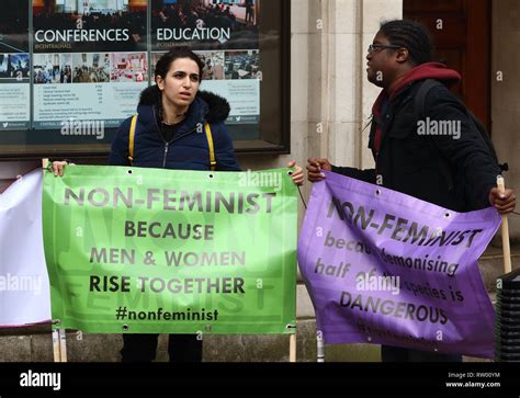 Two Demonstrators Seen Holding Banners During A Protest Against