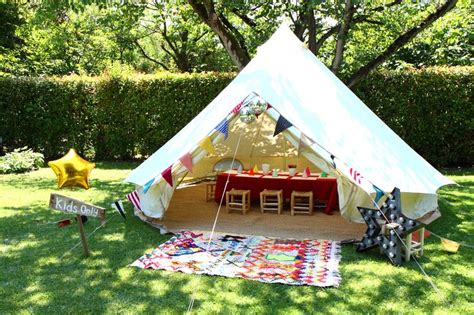 A Teepee Tent Set Up In The Middle Of A Yard With Picnic Table And Chairs