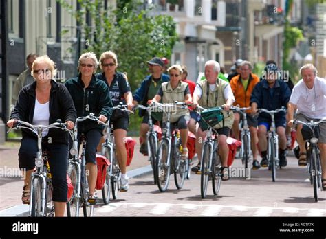 People Riding Bicycles On The Street In Amsterdam Netherlands Stock