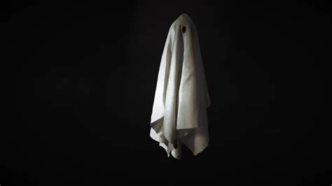 A ghost white sheet costume flying in the air with black background. Minimal Halloween scary ...