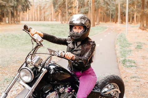 hermosa morena montando una moto en el parque imagen de archivo imagen de atractivo morena