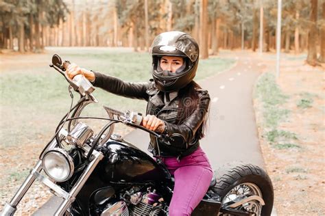 Hermosa Morena Montando Una Moto En El Parque Imagen De Archivo