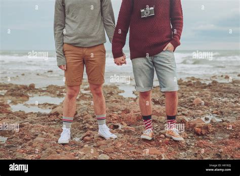 Jeune couple gay debout côte à côte sur la plage vue partielle Photo Stock Alamy