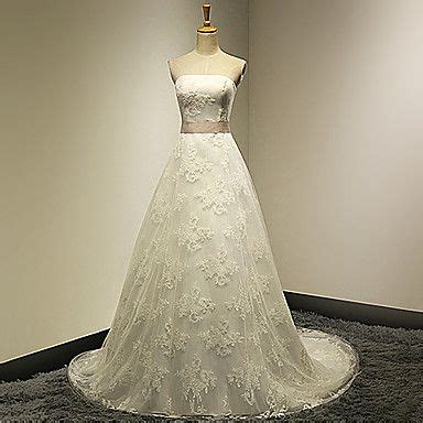 A Wedding Dress Is Displayed On A Mannequin In A Room With White Walls