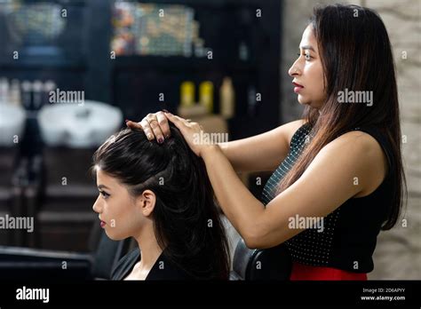 Female Hairdresser Standing And Making Hairstyle To Cute Lovely Young